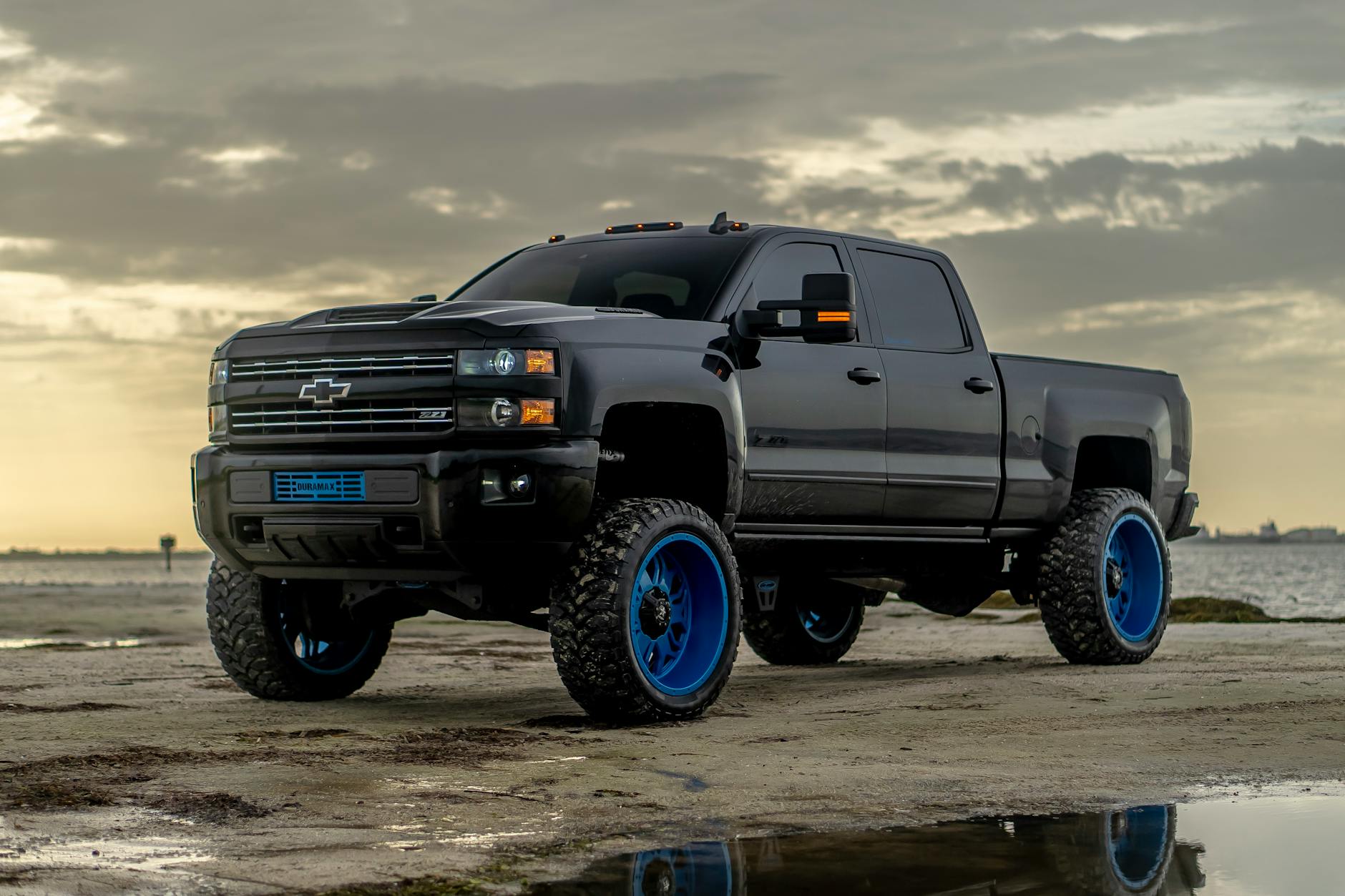 Black Chevrolet Silverado truck on beach